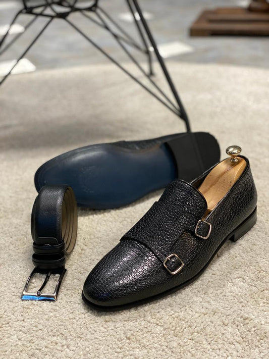 Black Grained Leather Double Monk Strap Shoes – one shoe showing blue sole, pair with shoe tree and matching belt on a rug, emphasizing material and style.