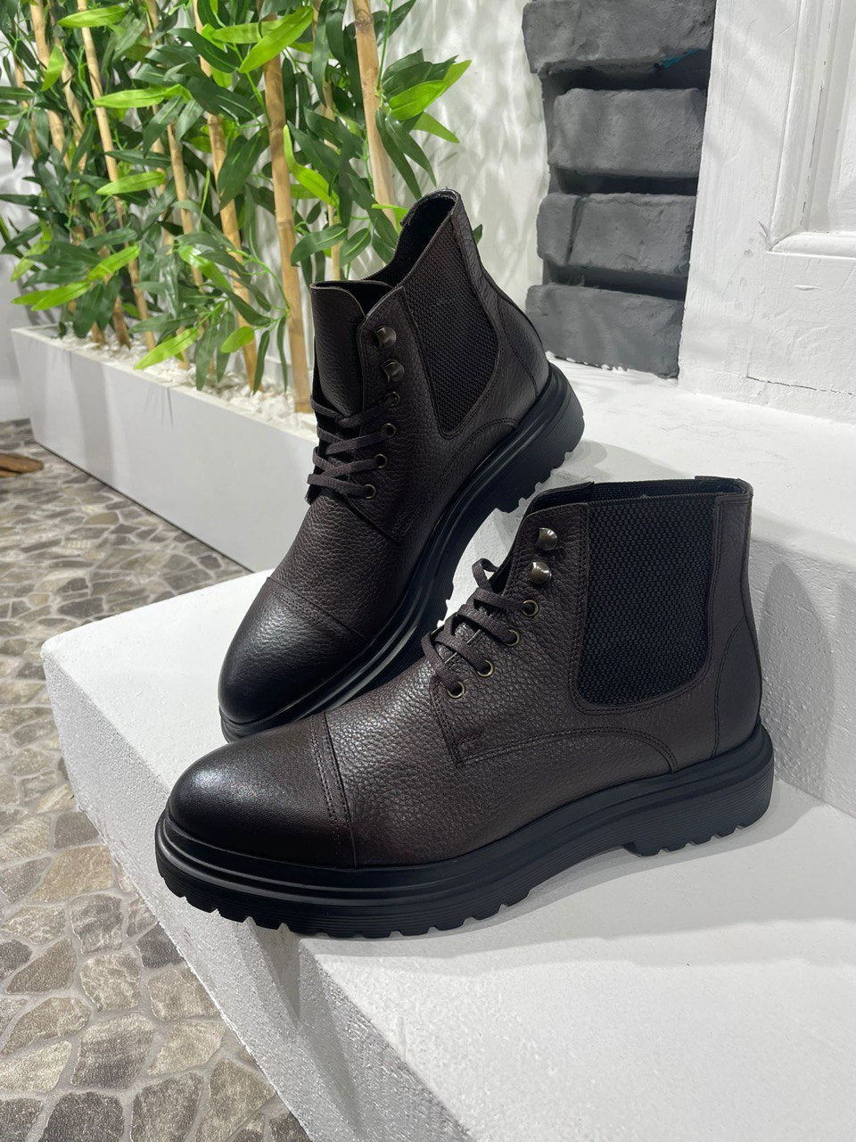 Handcrafted Brown Leather Ankle Boots for Rugged Style – a pair of brown leather boots on white steps, showcasing the full silhouette and robust sole.
