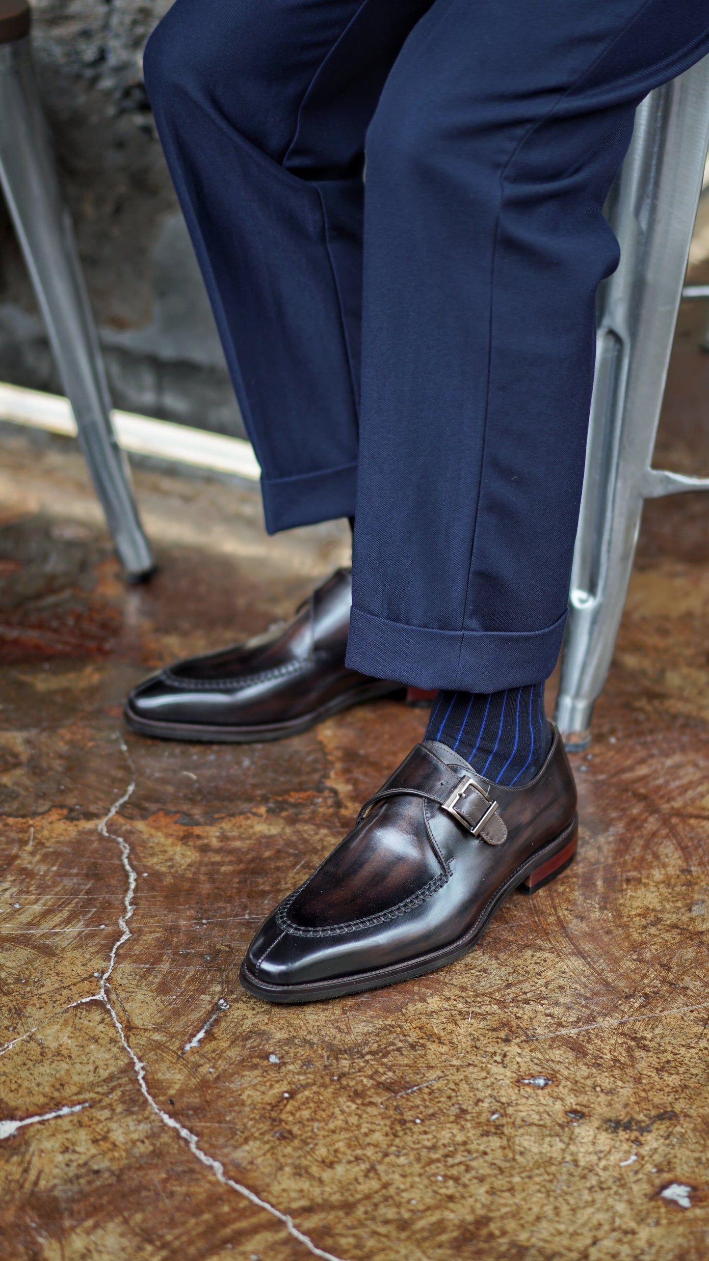 Handcrafted Dark Brown Single Monk Strap Shoes – worn by a man in navy cuffed trousers, showcasing polished leather and sleek design with apron stitching.