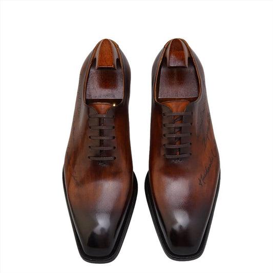 Handcrafted Marble Custom Leather Oxfords - Luxury Brown with custom text, displayed on a workbench.