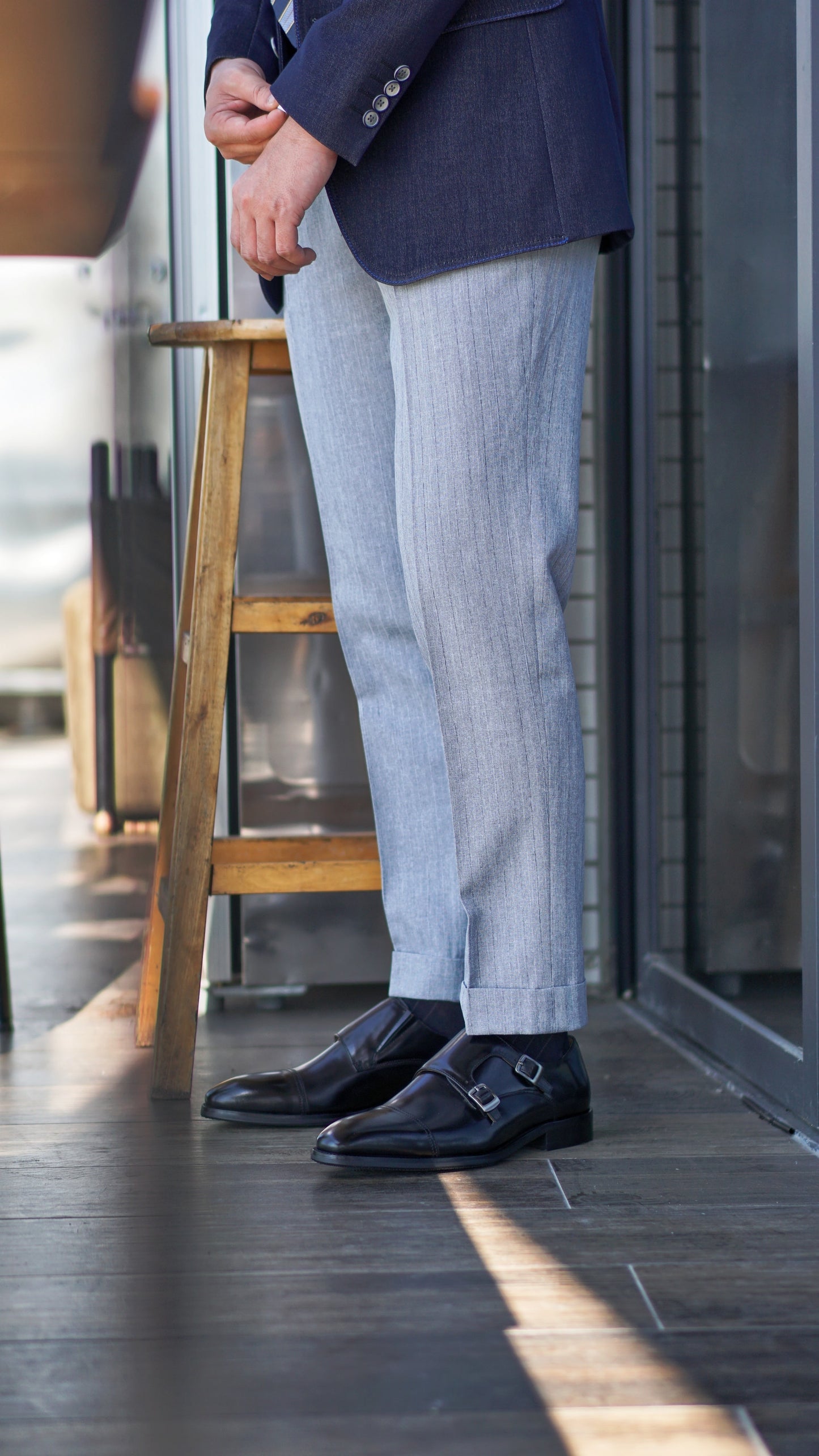 Handmade Black Double Monk Strap Dress Shoes – pair with one shoe upright on a concrete surface, emphasizing premium calf leather and sophisticated design.