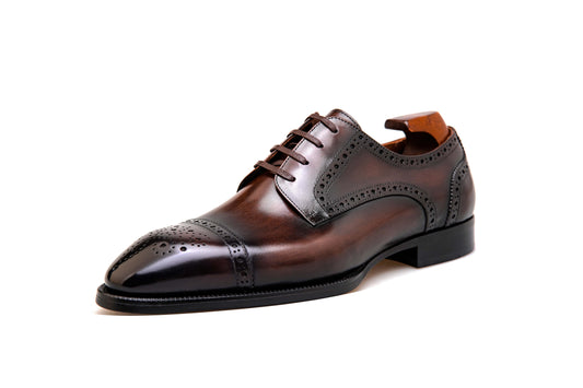 Single Heritage Cap-Toe Leather Derby Brogue shoe – deep brown hand-polished leather, side view with shoe tree and intricate broguing.