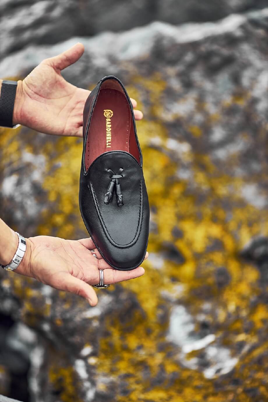 HolloShoe Black Tassel Loafers - Sophisticated Leather Footwear – held by a man's hands, highlighting premium black leather and classic tassel detail for versatile wear.