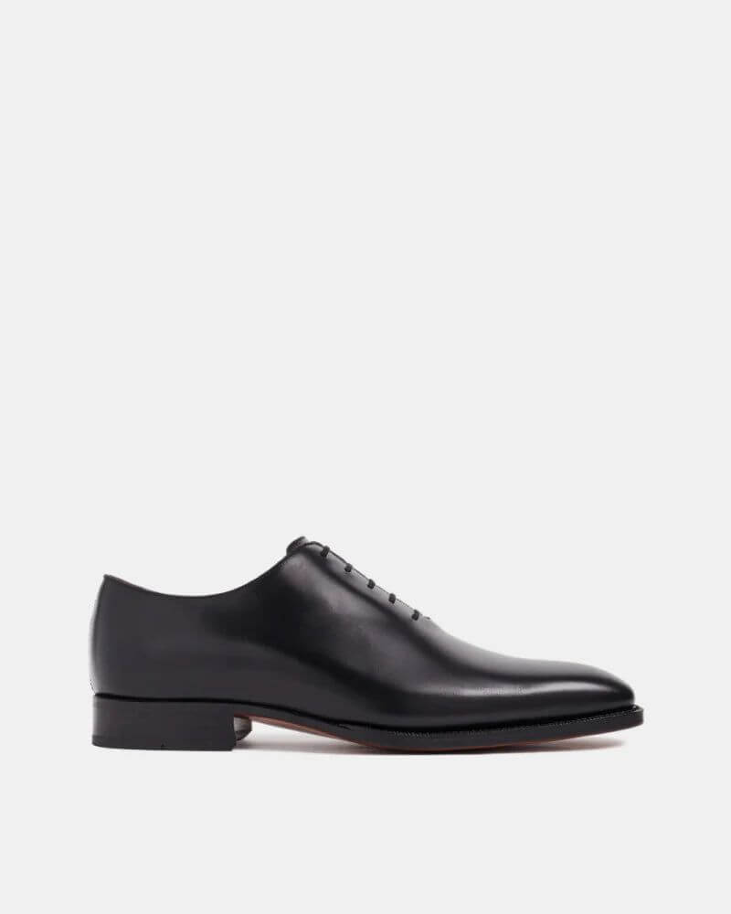 Black leather wholecut Oxford dress shoe – side view highlighting smooth leather finish, low heel, and sleek streamlined profile.