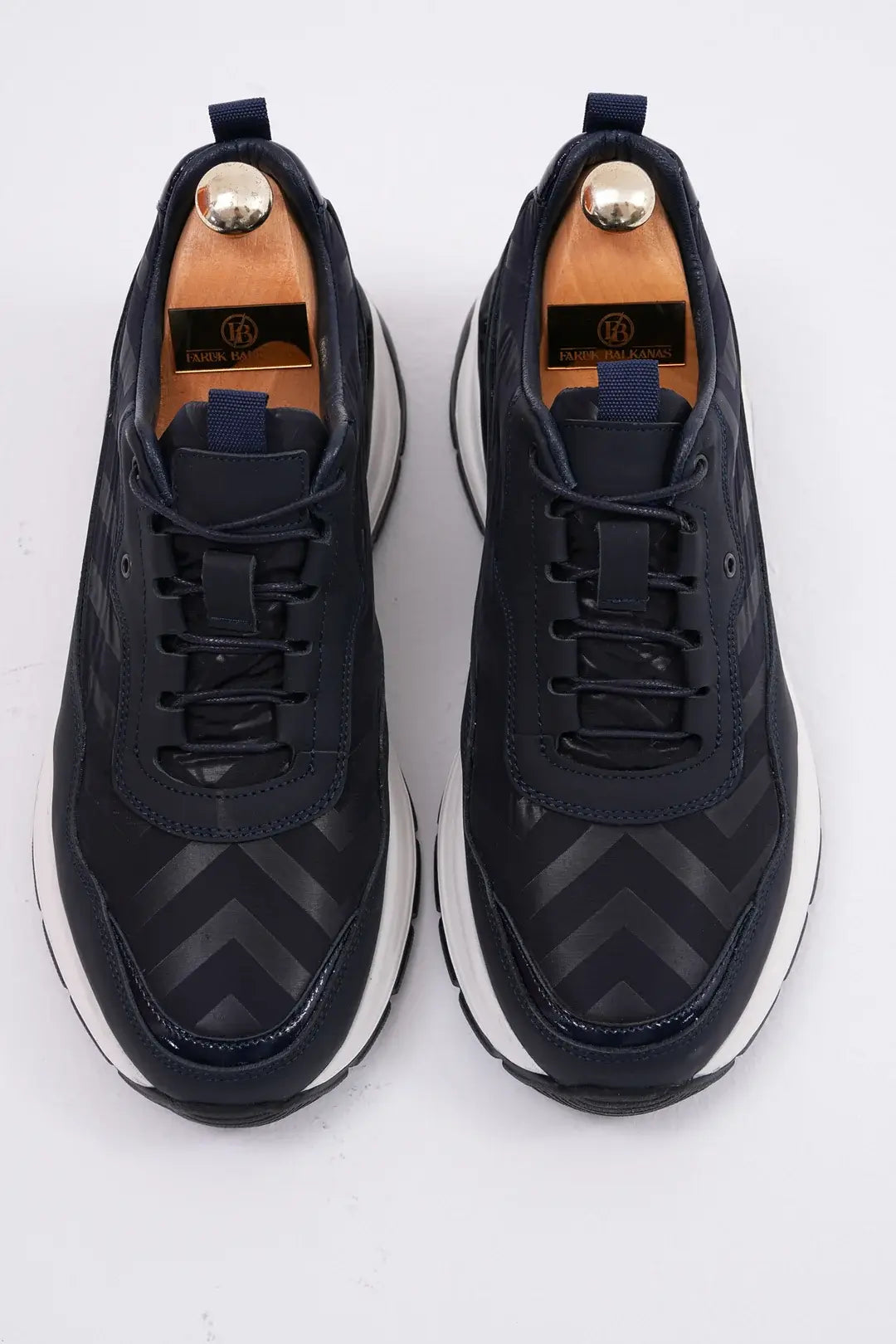 Midnight Motion Luxe Sneakers for Urban Energy – top-down view of pair with shoe trees, showcasing premium genuine leather, refined lace-up front, and geometric texture.