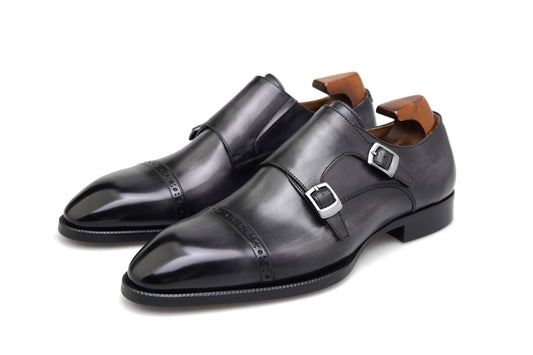 Polished Black Double Monk Strap Leather Shoes – side view on white background, highlighting high-gloss black full-grain leather, double buckle closure, and subtle cap-toe broguing.
