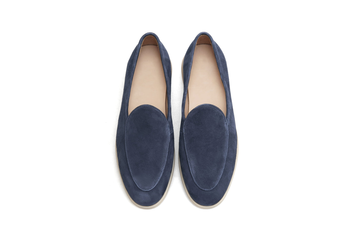 Pair of navy blue suede Venetian loafers on white background, heel and sole view