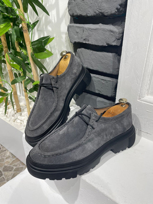 Stylish Grey Suede Lace-Up Chunky Shoes – urban footwear on a white ledge against a brick wall, with lace-up closure for secure fit.