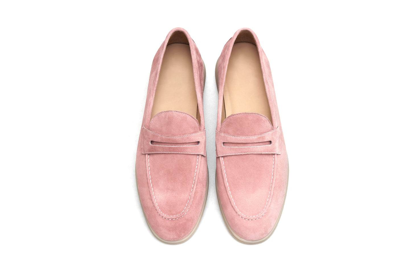 Pair of pink suede penny loafers on white background, front view