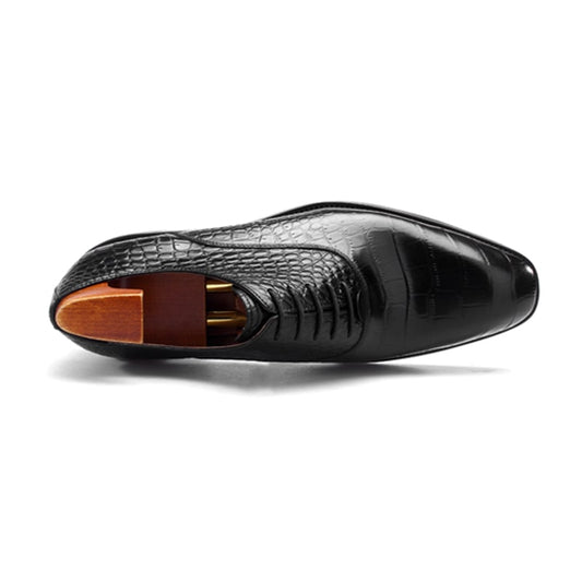 Top view of luxury black crocodile-print leather oxford shoe with sleek toe cap and premium wooden shoe tree insert.