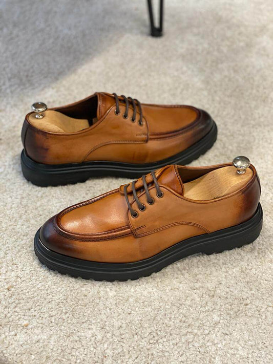 Camel Leather Derby Shoes – pair on a light rug with shoe trees, beside a matching camel leather belt, emphasizing lasting style and quality.