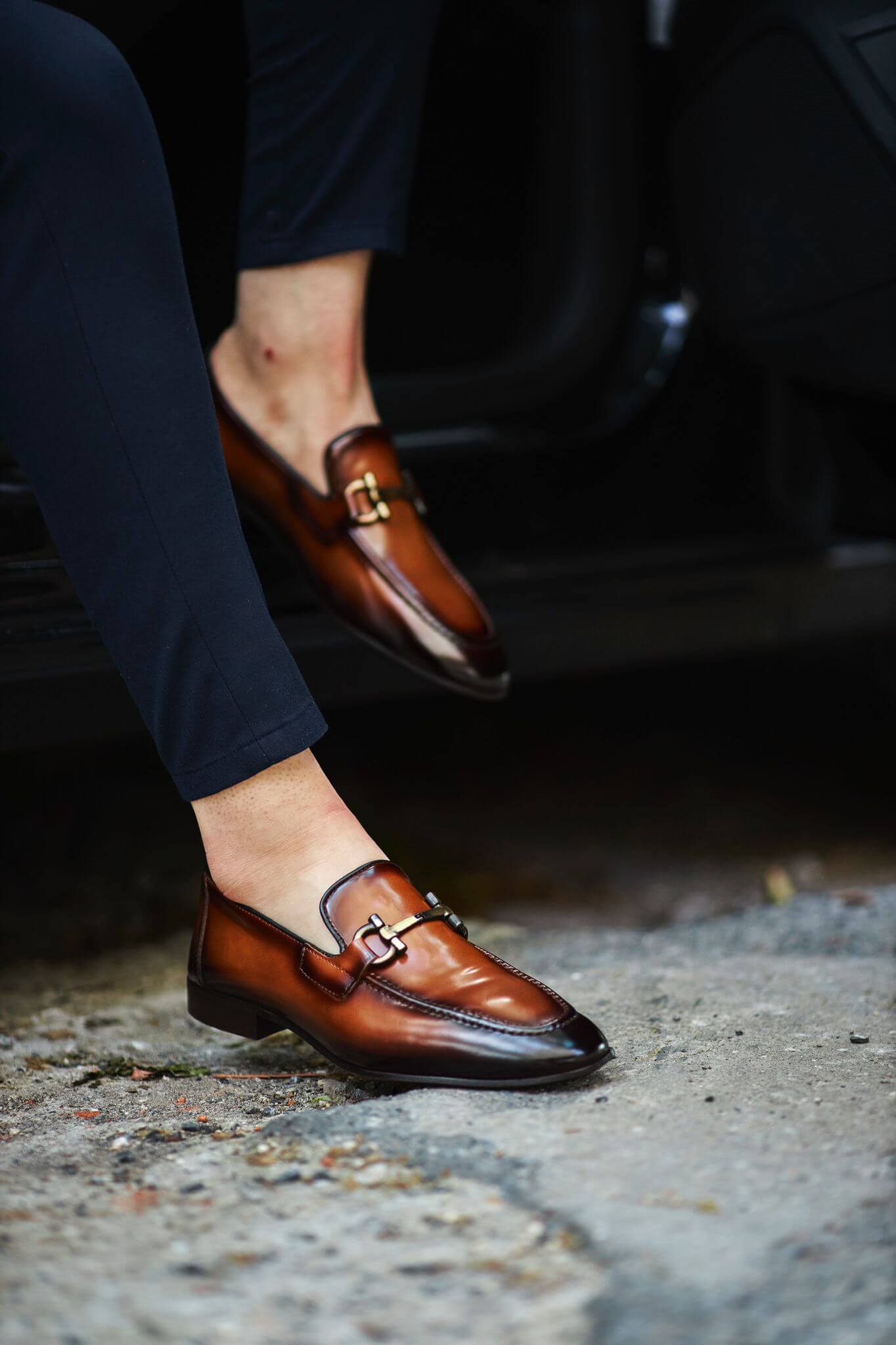Custer Camel Bit Loafers – Classic Leather Footwear for Every Occasion – worn by a man in dark trousers, stepping out of a car, showcasing a polished finish and a classic horsebit buckle.