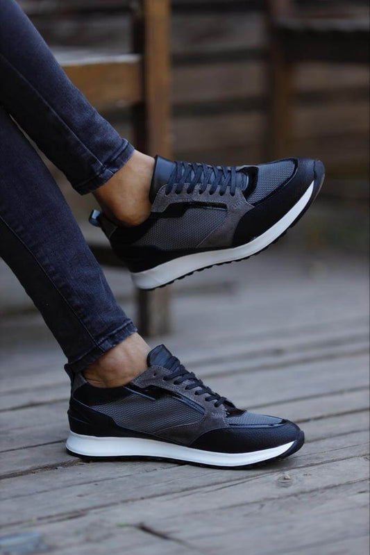 Detailed Gray Sneakers for Casual & Everyday Wear – worn by a man in black jeans, sitting on a wooden floor, highlighting unique detailing and a comfortable EVA sole.