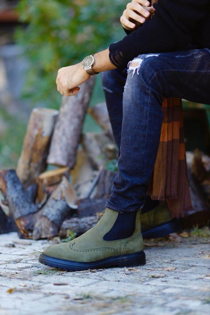 HolloShoe Khaki Nubuck Wingtip Chelsea Boots for All-Day Comfort – a side view of a man sitting with the boots on, focusing on the quality of the nubuck and the casual style.