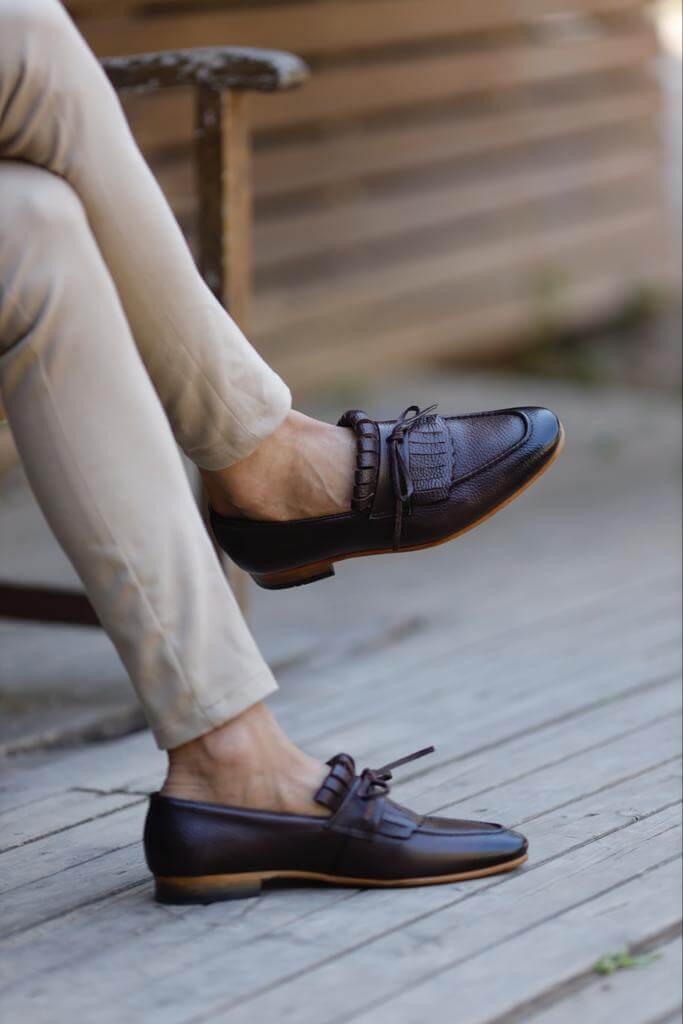 Brown penny loafers with penny slot detail.