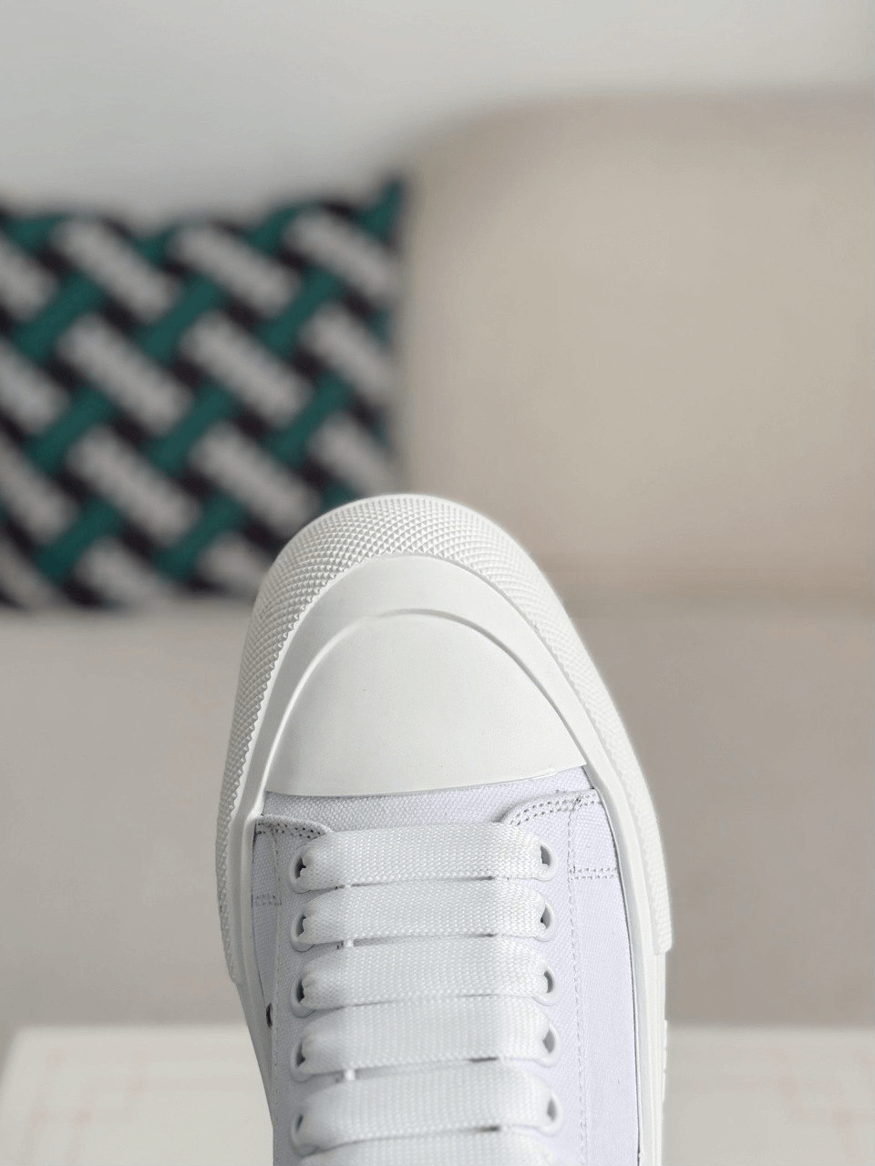 White sneaker on a blurred indoor background