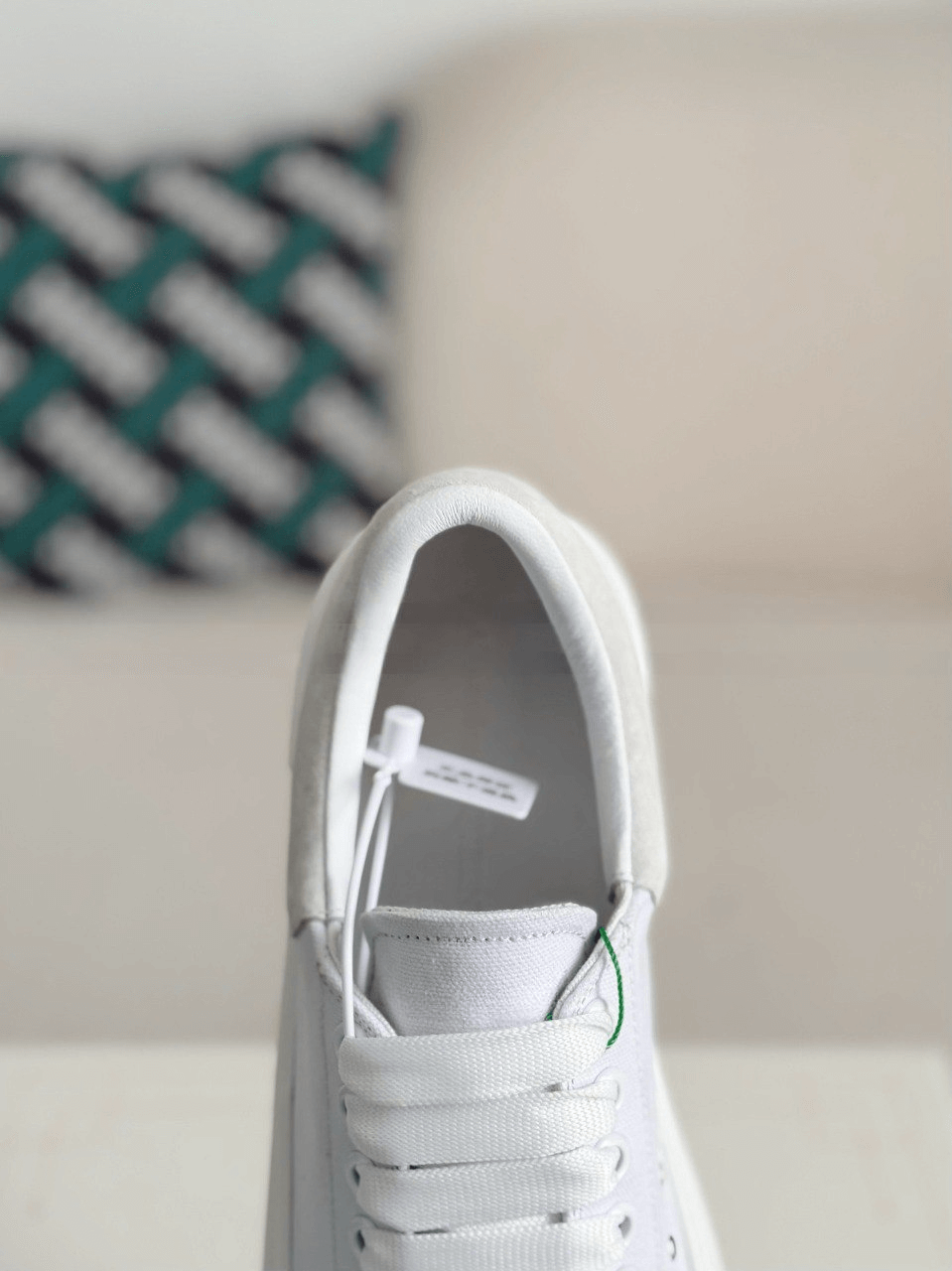 White sneaker on a light-colored surface with a blurred background