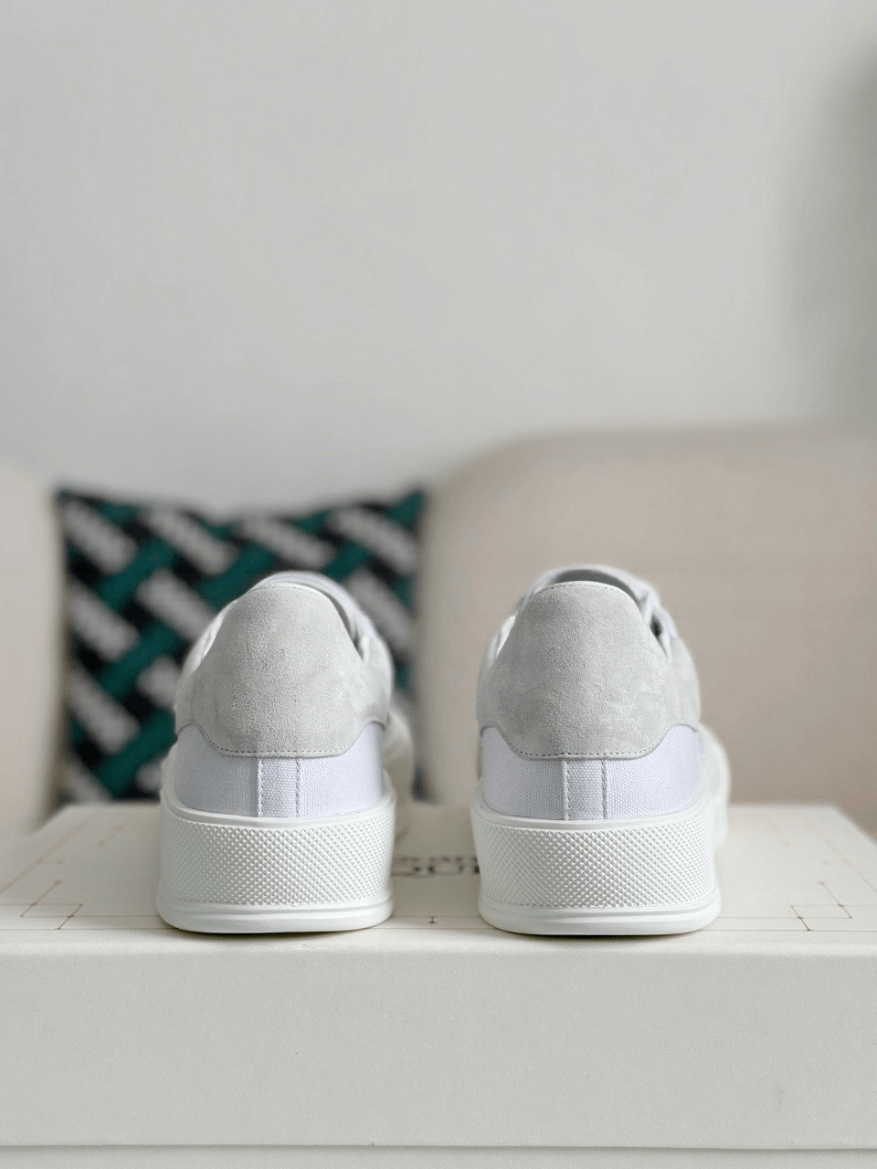Pair of gray sneakers on a white surface with a neutral background