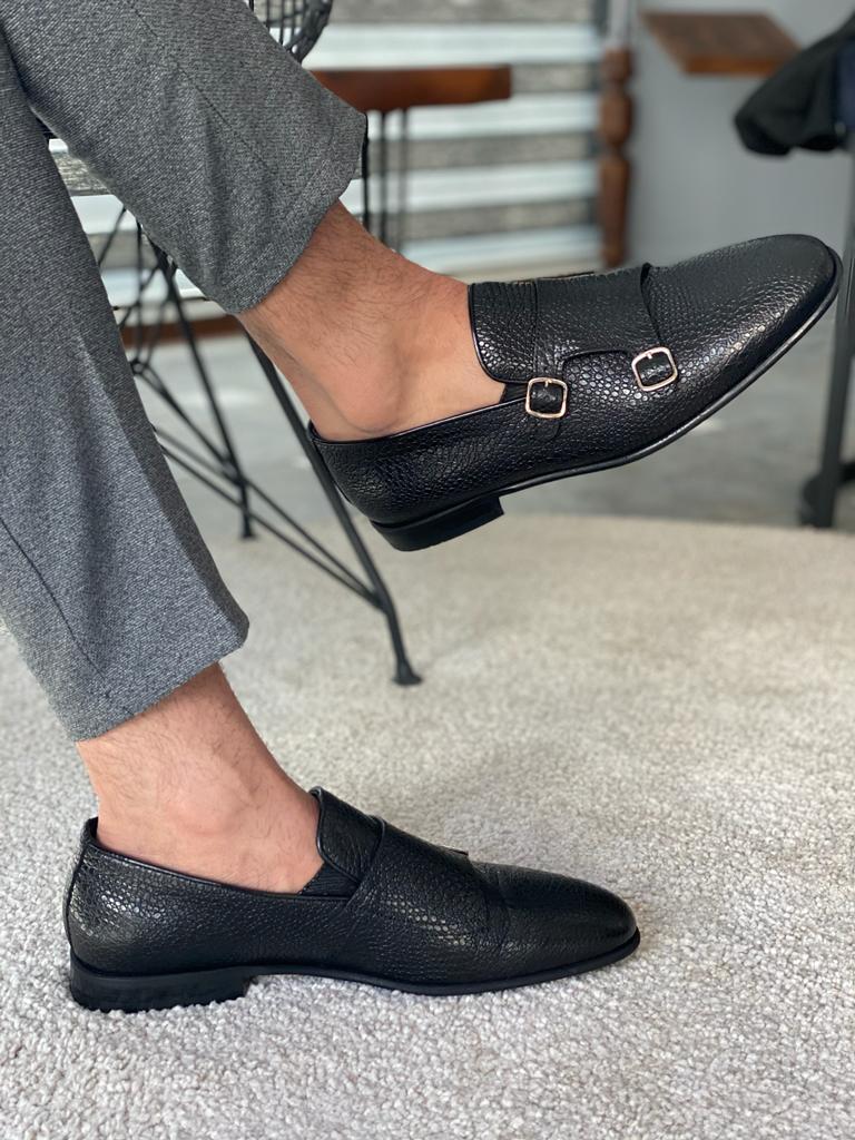 Black Grained Leather Double Monk Strap Shoes – worn by a man in grey trousers, showcasing textured leather and double buckle design on a rug.