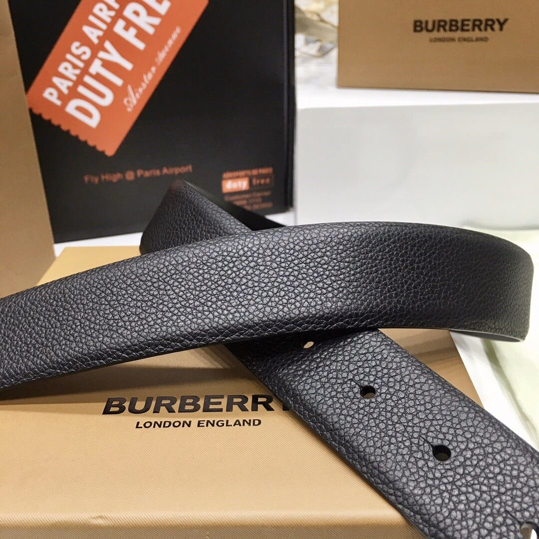 Black Burberry belt on a Burberry box with a duty free sign in the background.