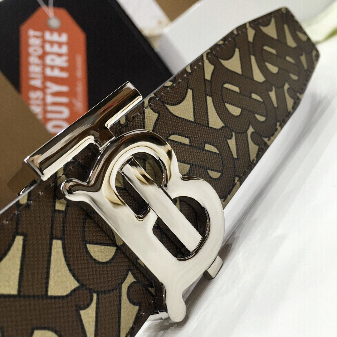 Close-up of a patterned belt with a prominent buckle, featuring a visible brand logo.