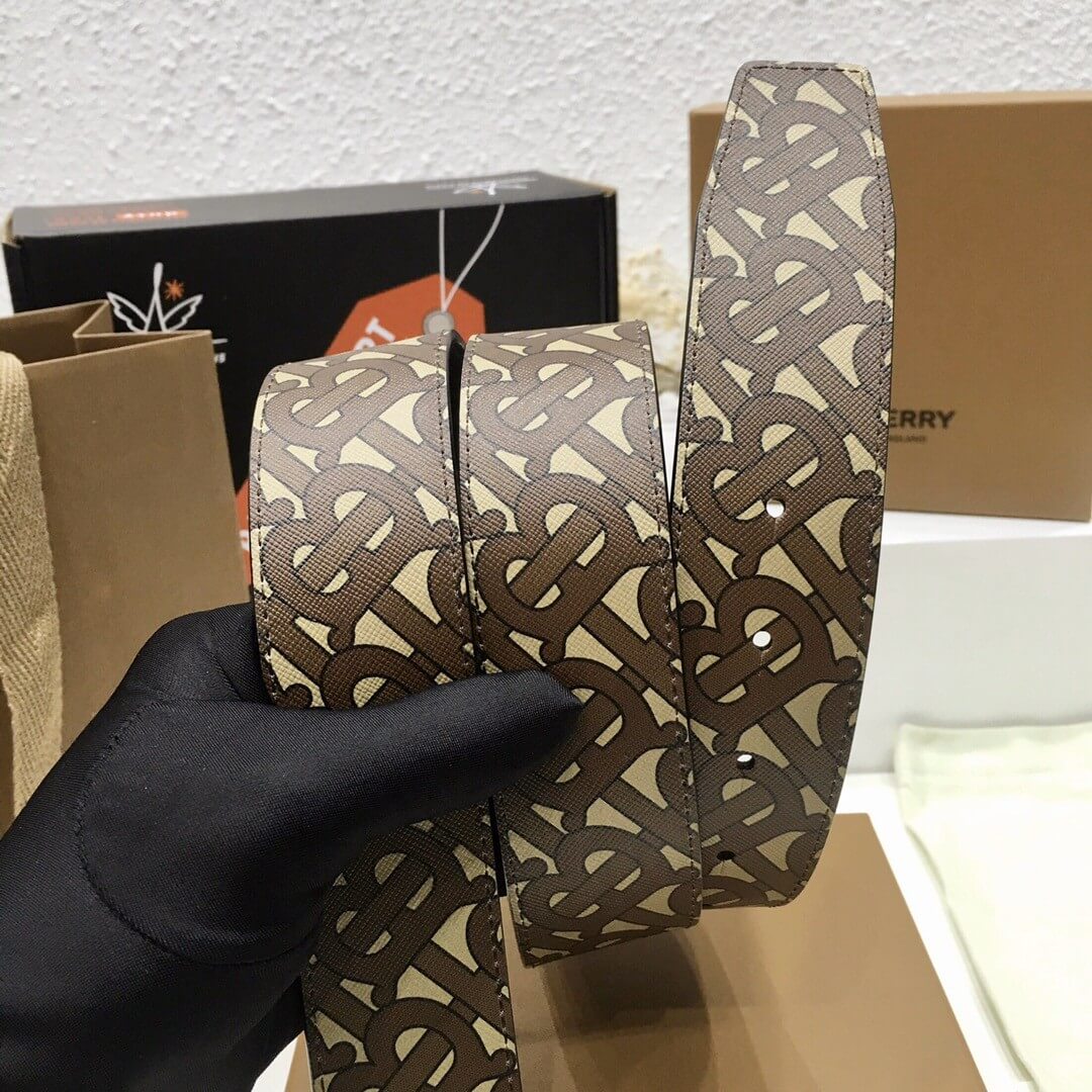 Patterned belt held by a gloved hand with boxes in the background