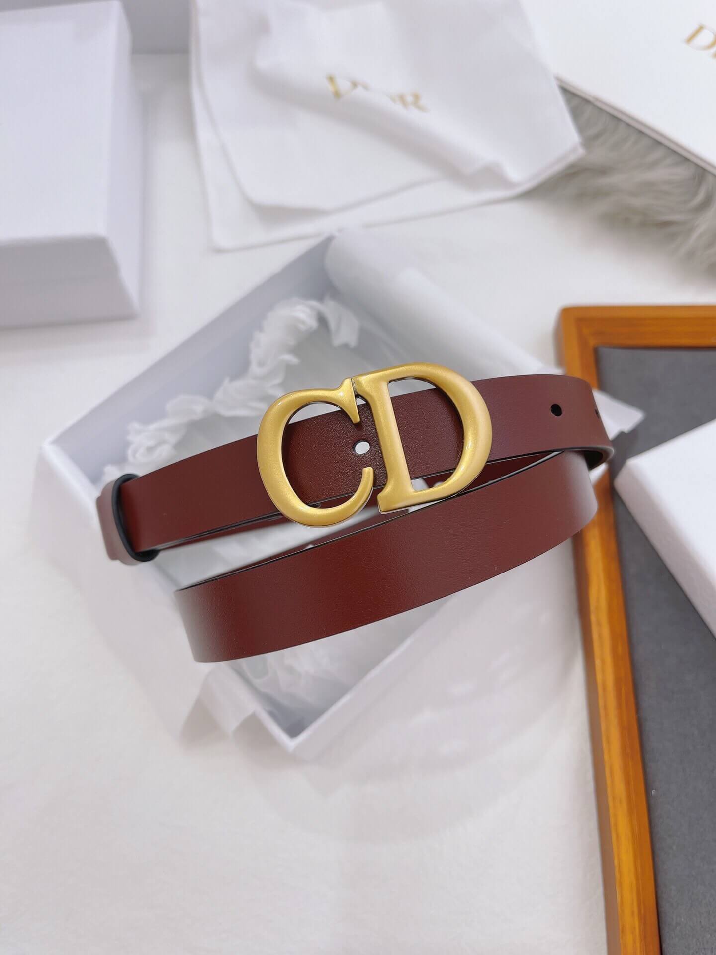 Brown belt with gold logo on a white background