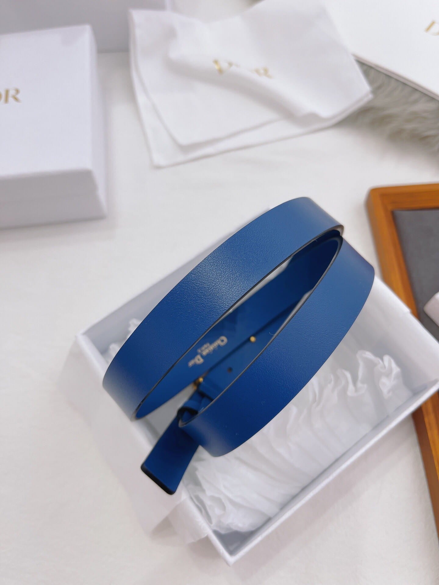 Blue belt on a white surface with a visible brand logo.