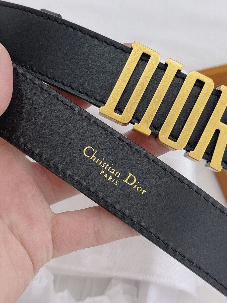 Black belt with gold buckle featuring Christian Dior logo.