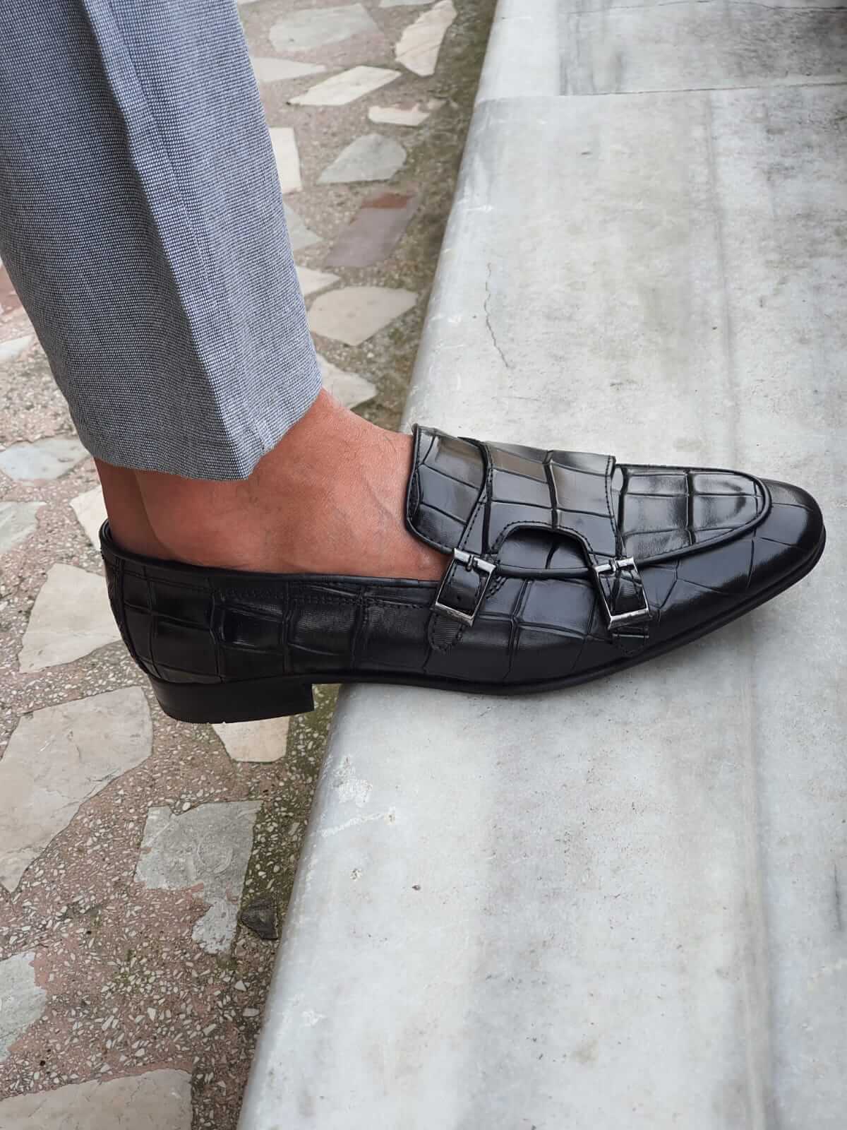 Black Crocodile-Embossed Double Monk Strap Shoe – worn by a man in light grey trousers, close-up side view, emphasizing the unique crocodile texture and polished buckles