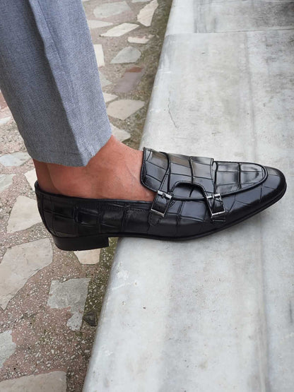 Black Crocodile-Embossed Double Monk Strap Shoe – worn by a man in light grey trousers, close-up side view, emphasizing the unique crocodile texture and polished buckles