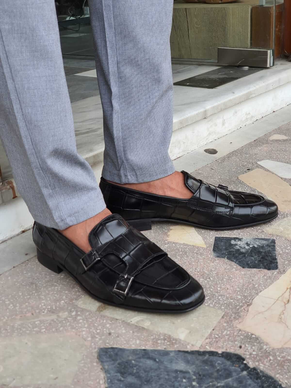 Black Crocodile-Embossed Double Monk Strap Shoes – pair worn by a man in light grey trousers, showcasing the bold crocodile pattern and sophisticated double monk strap design