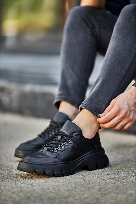 Classic Black Lace Detail Chunky Sneakers - Elegant Leather Footwear for Men – worn by a man in black jeans, showcasing sleek black leather and a chunky sole.