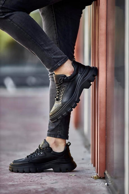 Classic Black Lace Detail Chunky Sneakers - Elegant Leather Footwear for Men – side view, worn by a man in black jeans, leaning against a wall, highlighting the chunky sole and durable construction.