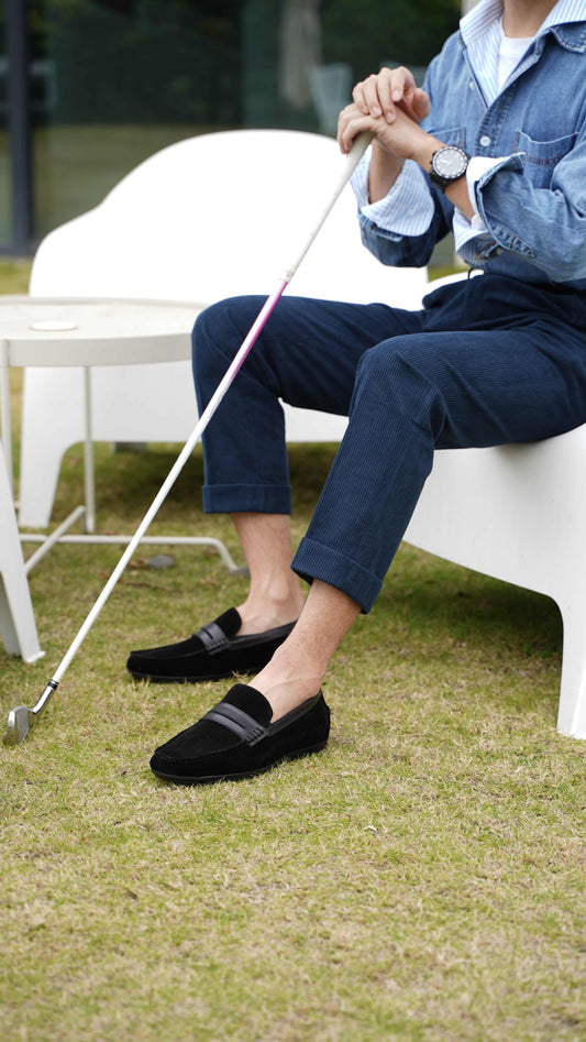Classic Black Suede Driving Loafers for Everyday Sophistication – worn by a man in a denim shirt and navy trousers, holding a golf club, showcasing a classic and sophisticated look.