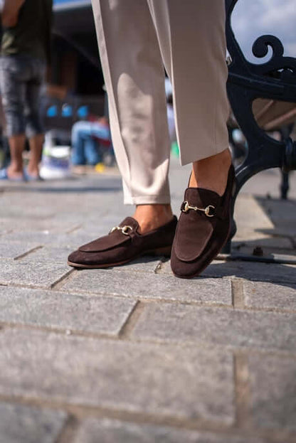 Classic Brown Suede Bit Loafers for Office & Evening Wear – worn by a man in light trousers, with feet on a stone-paved ground, showcasing timeless style and a refined touch with metal bit.