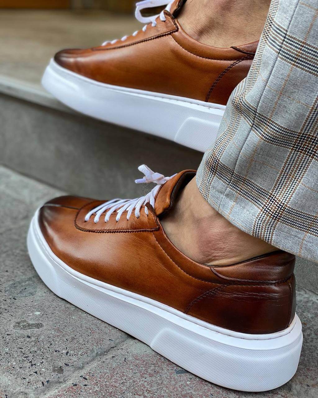 Classic Camel Leather Sneakers for Active Lifestyles & All-Day Wear – sleek brown genuine leather, worn by a man in plaid trousers on steps, showcasing timeless design and luxurious feel.