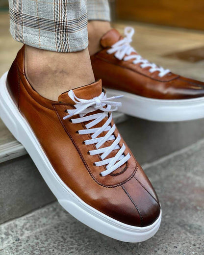 Classic Camel Leather Sneakers for Active Lifestyles & All-Day Wear – sleek brown genuine leather, worn by a man in plaid trousers on steps, highlighting comfort and modern design.