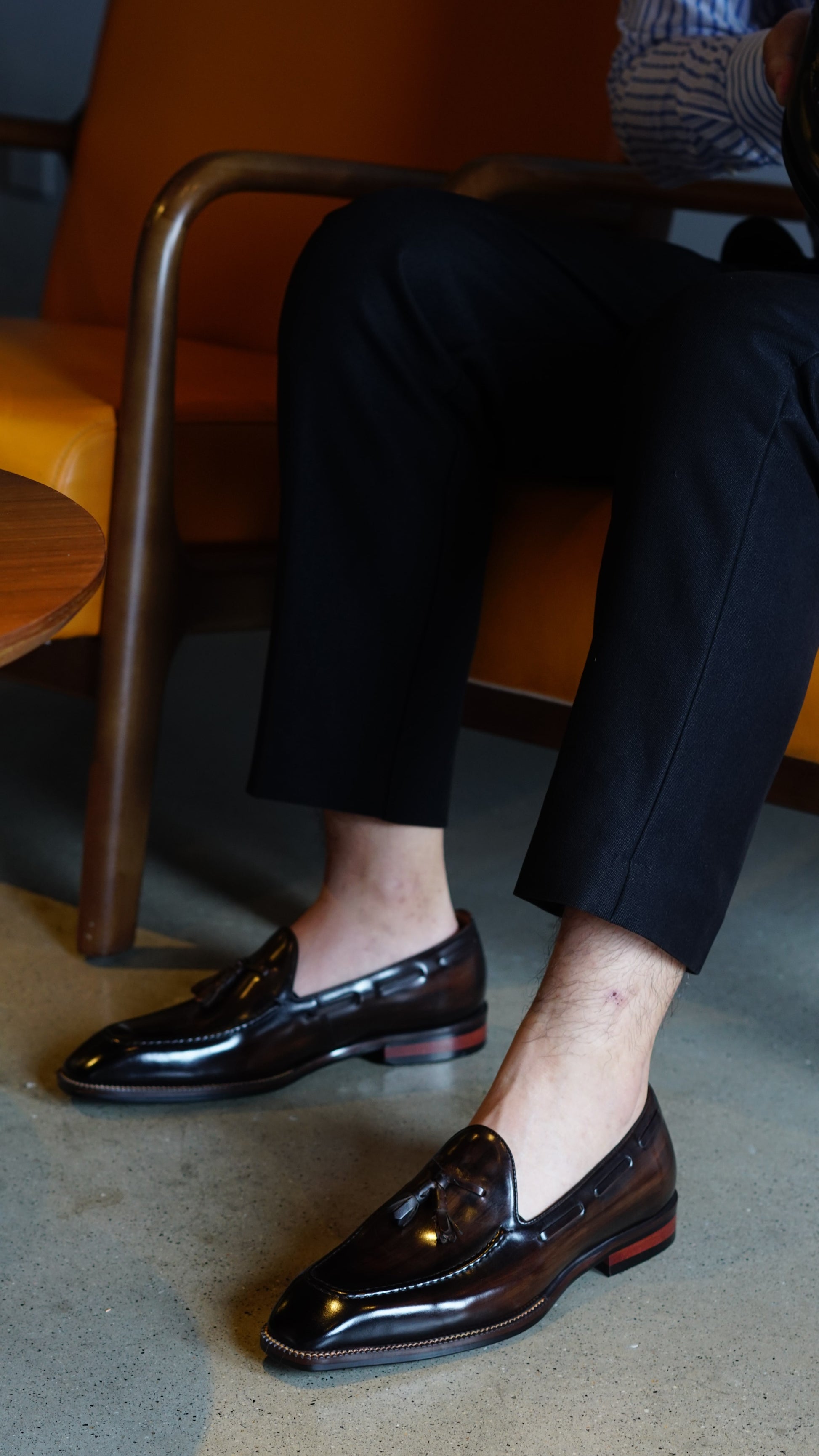 Hand-Made Dark Brown Leather Tassel Loafers – worn by a man in black trousers, showcasing the sleek profile, polished finish, and classic tassel detail.