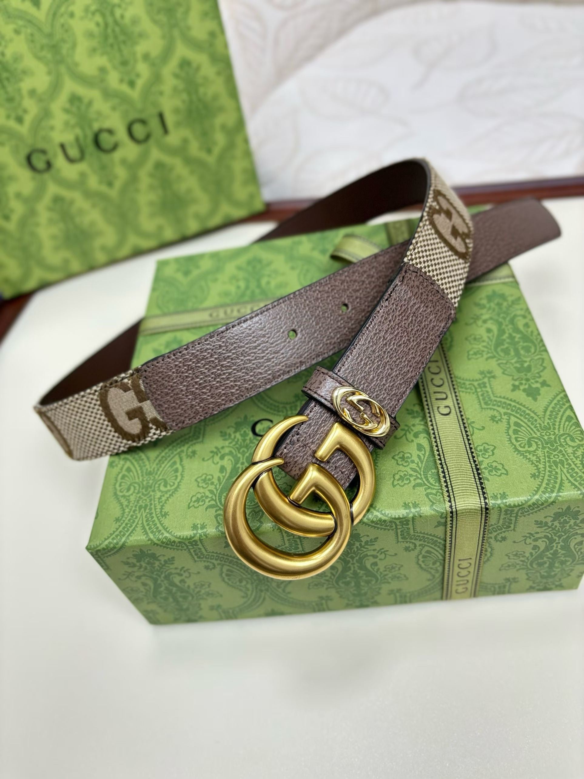Gucci belt with gold buckle on a green box