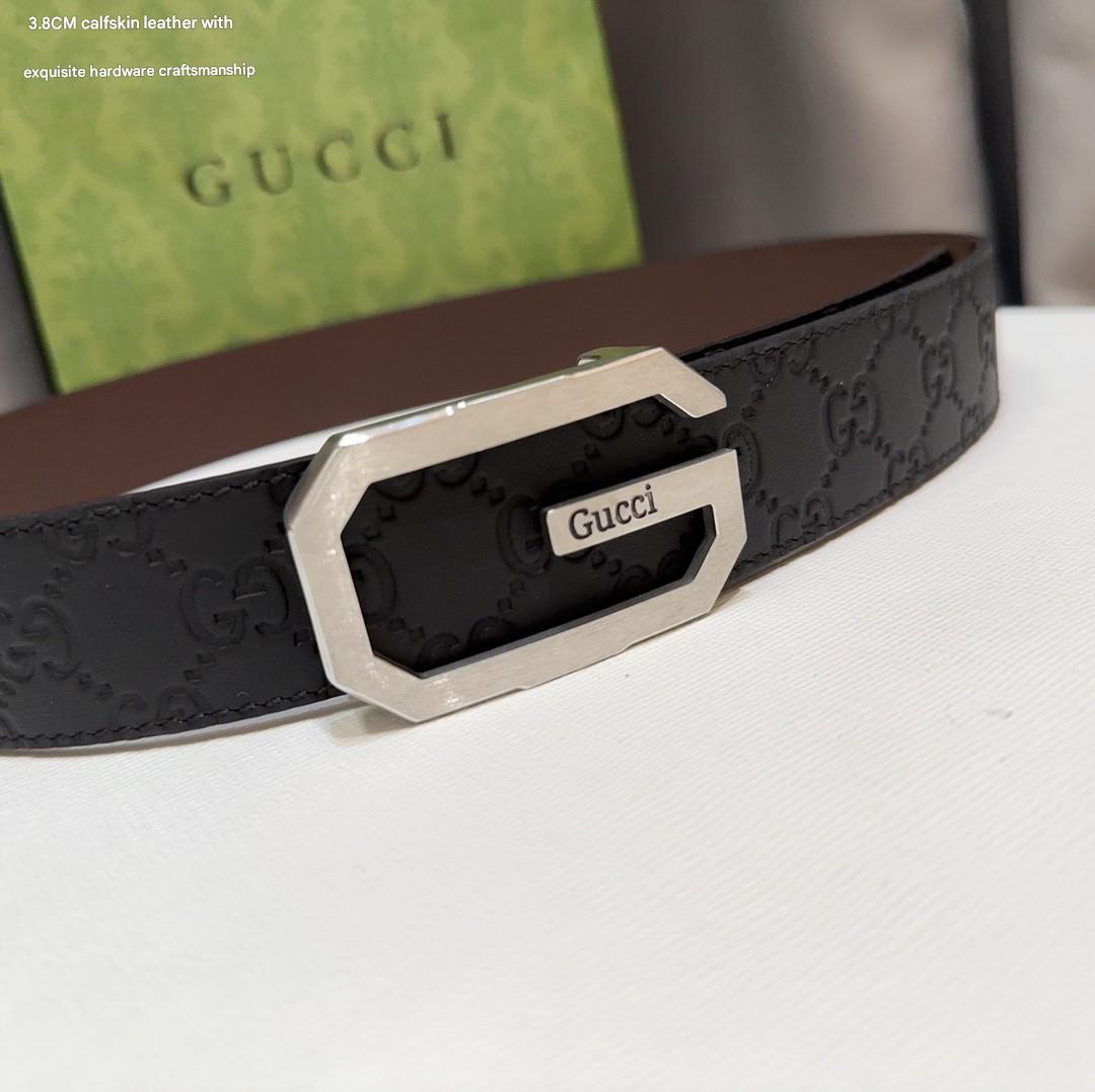 Black Gucci belt with silver buckle on a white surface