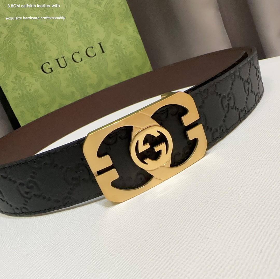 Gucci belt with gold buckle on a white surface, Gucci box in the background