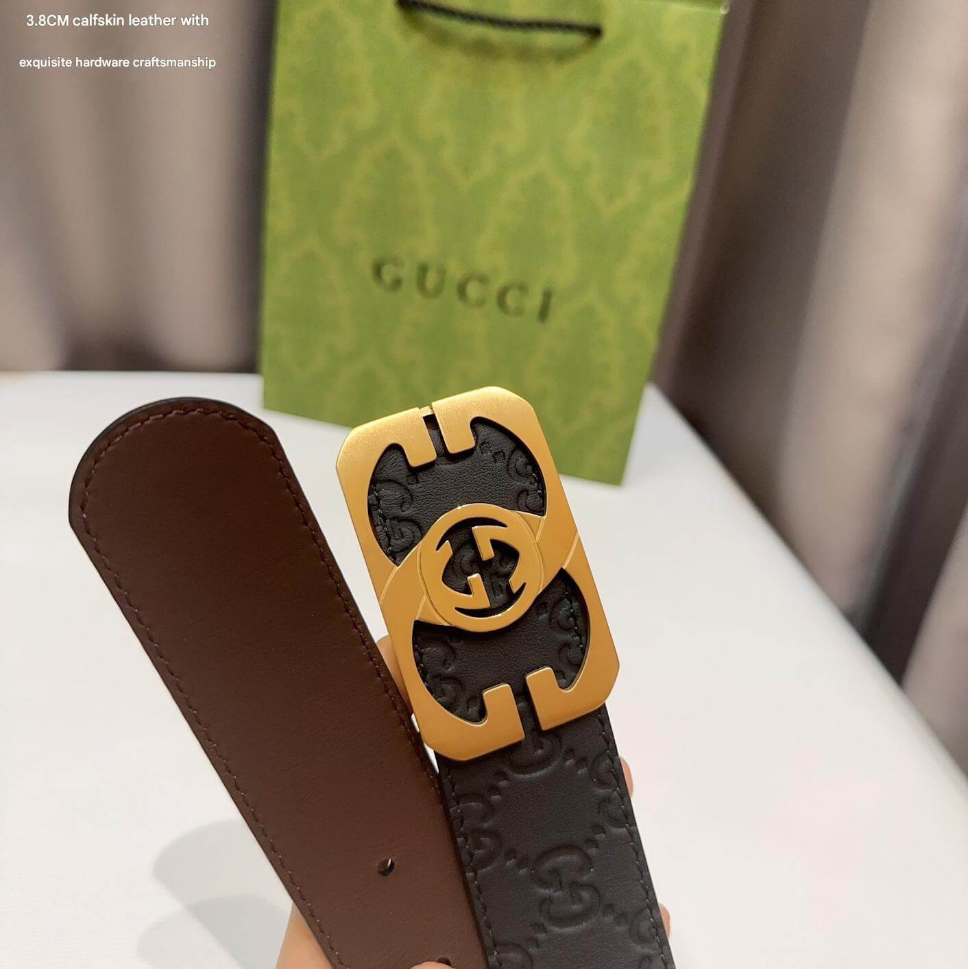 Brown leather belt with gold buckle in front of a Gucci branded bag.