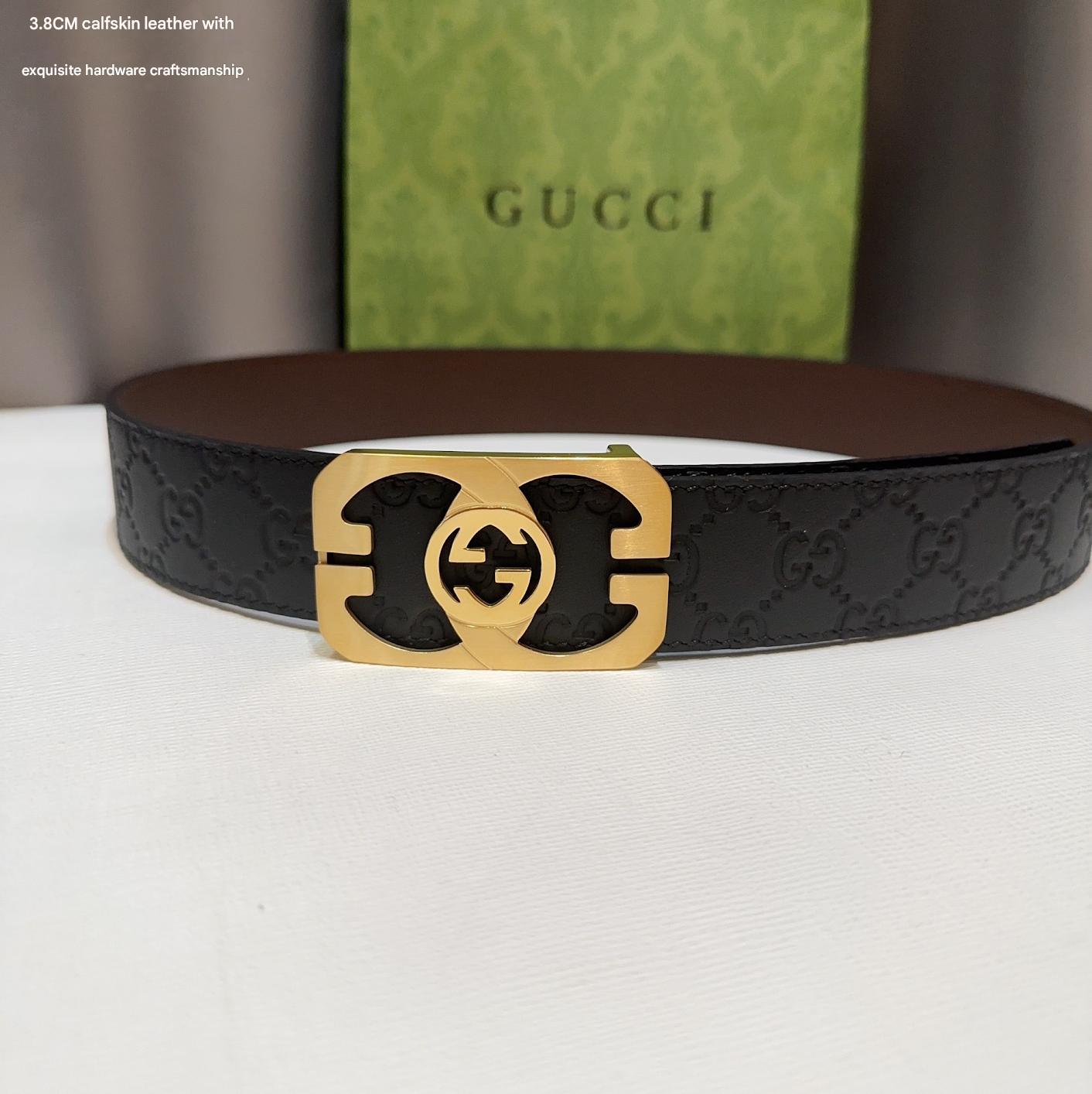 Black Gucci belt with gold buckle on a white surface, Gucci box in the background.