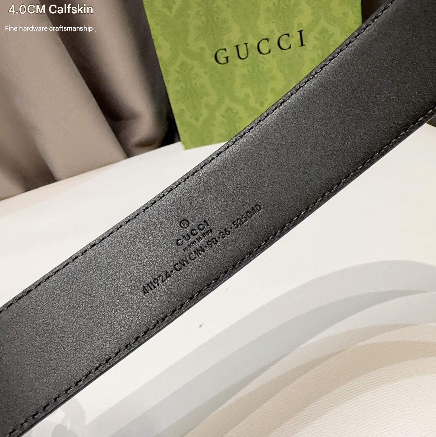 Gray Gucci belt with brand logo on a neutral background