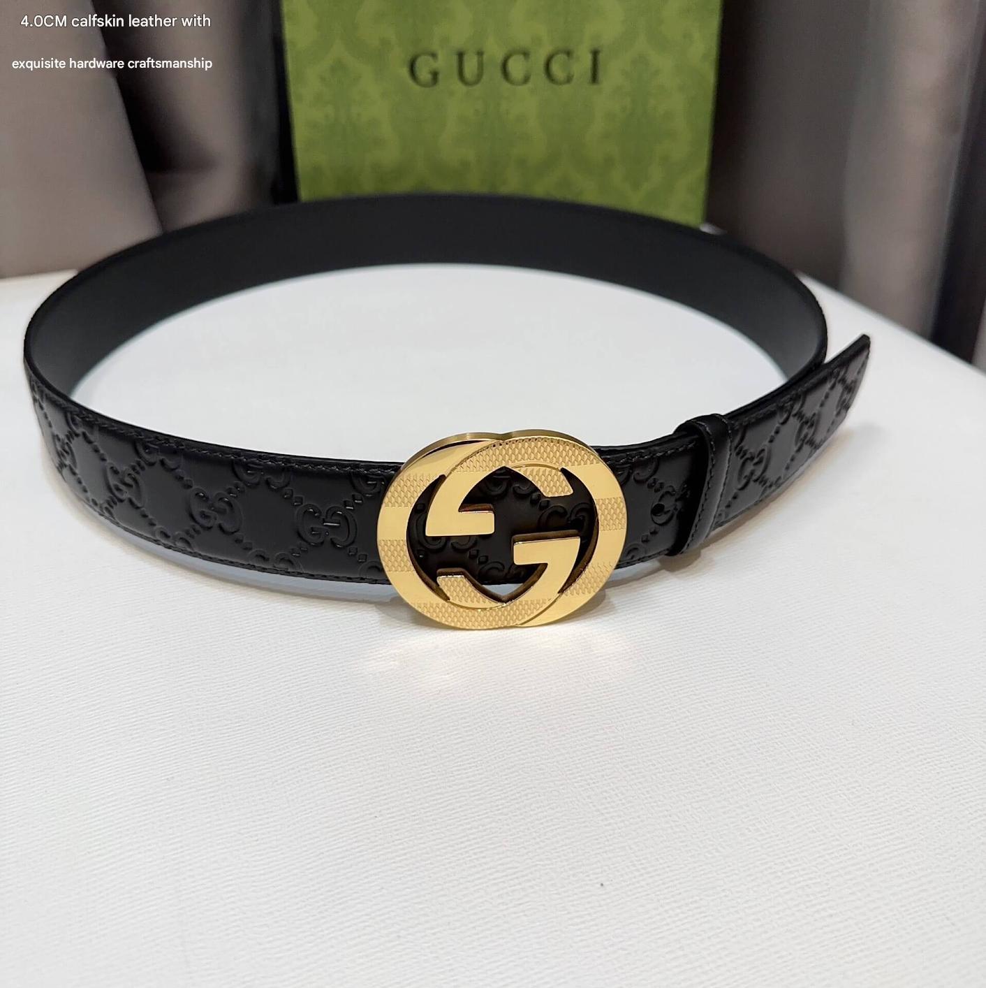 Black Gucci belt with gold interlocking G buckle on a white surface, Gucci box in the background.
