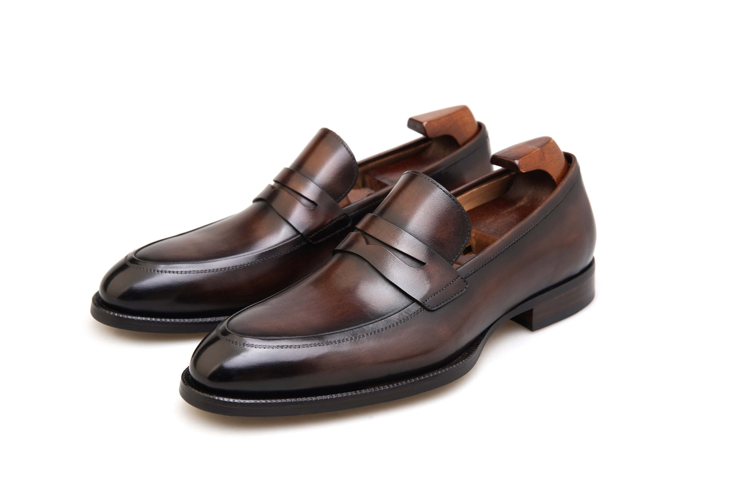 Hand-Burnished Brown Leather Penny Loafers – pair on white background, showcasing the rich hand-polished finish, classic penny strap, and raised apron toe.