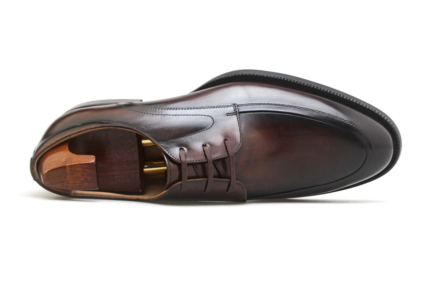 Top-down view of a single HolloShoe Hand-Burnished Chestnut Split-Toe Derby shoe with a shoe tree, highlighting the hand-burnished finish and apron toe.