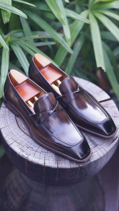 Hand-Painted Dark Brown Leather Penny Loafers – pair with shoe trees on a wooden stump, showcasing rich hand-painted patina finish.