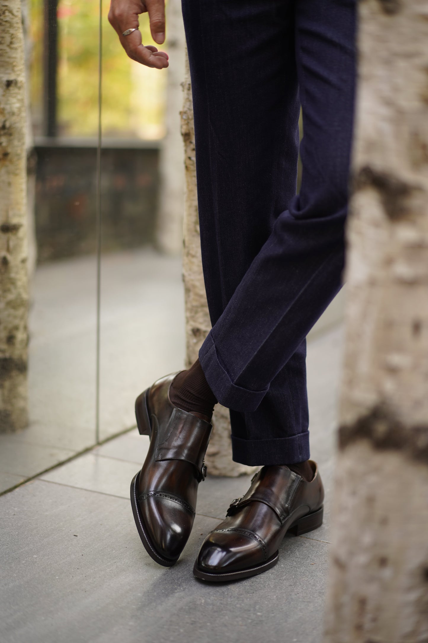 Hand-Polished Smoked Chocolate Double Monk Strap Shoes – worn by a man in cuffed dark blue jeans, showcasing unique character and modern elegance.